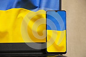 The national flag of Ukraine is yellow-blue as a background on the phone and laptop, peace in Ukraine, no war, free country