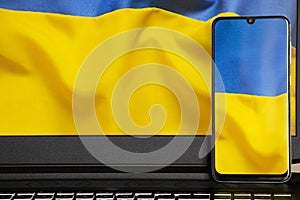 The national flag of Ukraine is yellow-blue as a background on the phone and laptop, peace in Ukraine, no war, free country