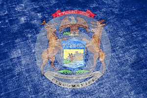 The national flag of the US state Michigan in against a gray textile rag on the day of independence in different colors of blue