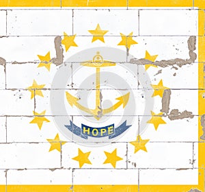 National flag of US state of Rhode Island on white cloth in center in a circle of thirteen golden five-pointed stars. In center is