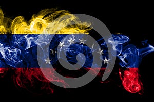 National flag of Venezuela made from colored smoke isolated on black background. Abstract silky wave background.