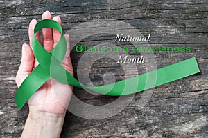 National Glaucoma Awareness Month in January with Green ribbon on helping hand bow isolated with clipping path
