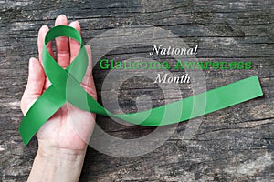 National Glaucoma Awareness Month in January with Green ribbon on helping hand bow isolated with clipping path photo