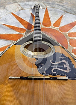 The national Greek stringed plucked musical instrument Bouzouki lies on a marble table in Greece