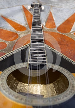 The national Greek stringed plucked musical instrument Bouzouki lies on a marble table in Greece