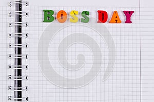 National Happy Boss Day. Multicolored colorful letters in a squared exercise book on the table. Bosses Day office