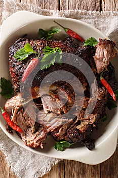 National Latin American dish of Pernil Asado shredded pork closeup on a plate. Vertical top view