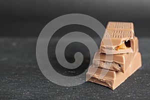 National Milk Chocolate Day stock images. Pile of chocolate with nuts images. Chocolate isolated on a brown background. Milk