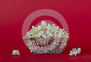National popcorn day concept. Shopping cart full of popcorn. Leisure idea. Copy space.