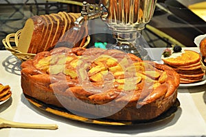 National Russian cuisine. Samovar, pies, pancakes, bread on the table.