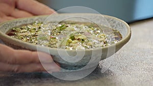 national traditional Russian dish - okroshka on a plate spinning on a wooden background.
