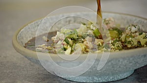 national traditional Russian dish - okroshka on a plate spinning on a wooden background.