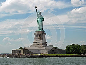 Statute of Liberty near Ellis Island with Cloudy sky Background photo