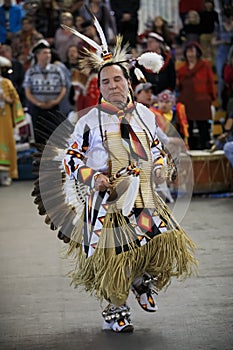 Native American Indians dressed in intricate and colorful traditional outfits dancing at a powwow in San Francisco, USA