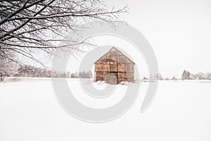 Native American Longhouse surrounded with white snow on the ground during winter