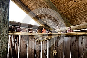 Native American pottery, pipes, and other items rest on a bundled reed shelf inside a Summer House