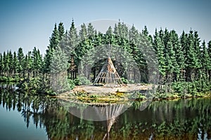 Native American tipi reflecting in the lake