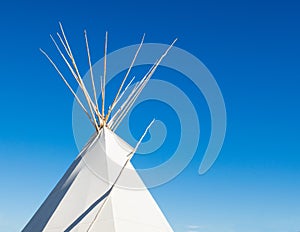 Native American tipi under blue sky