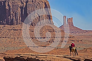 A native American walks his horse in Monument Valley.