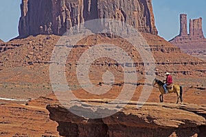 A native American walks his horse in Monument Valley.