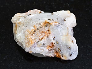 native gold in rough quartz stone on dark