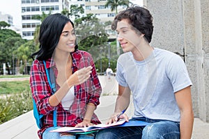 Native latin american female student in discussion with caucasian friend