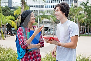 Native latin american female student talking with caucasian friend