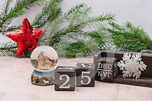 Nativity scene about the Birth of Jesus Christ in a glass ball. Calendar cubes and spruce branches on a gray background. Christmas