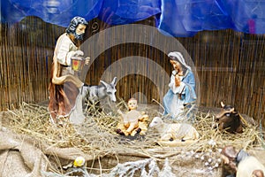 Nativity scene, holy family figurines on hay. Birth of savior Jesus Christ, Christmas essence