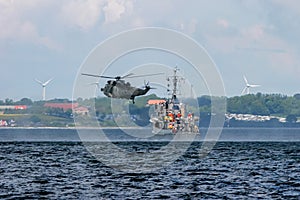 NATO rescue mission in sea with ship and helicopter