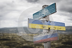 nato, ukraine and russia flag on signpost outdoors photo
