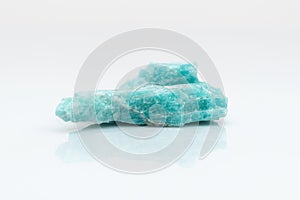Natural amazonite gemstone isolated on white background. A bluish-green crystal on a white background. A variety of