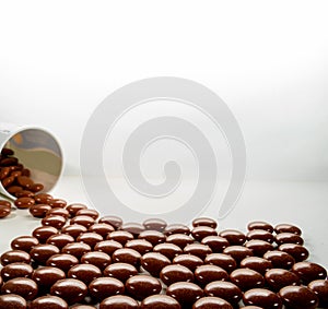 Natural Anti stress  or sleeping tablets to help relax spilling out of bottle on white background ,alternative herbal medicine