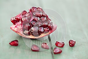 Natural antioxidant, pomegranate seeds on a wooden background