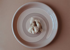 Natural antiviral ginger root on plate, brown background