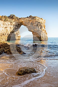 Natural arch above ocean, Algarve, Portugal. View of the natural stone arch during beautiful sunny day