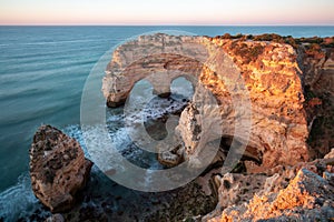 Natural arch above ocean, Algarve, Portugal. View of the natural stone arch during beautiful sunny day
