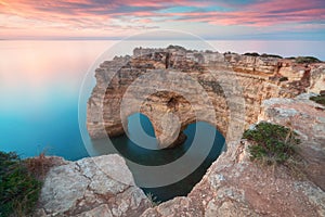 Natural arch above ocean. Natural caves at Marinha beach,  Algarve, Lagoa portugal. Stone arch at beach. Summer season.