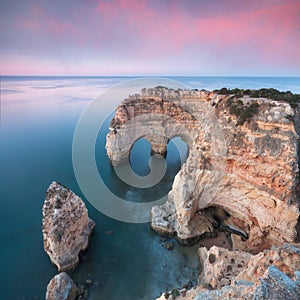 Natural arch above ocean. Natural caves at Marinha beach,  Algarve, Lagoa portugal. Stone arch at beach. Summer season.