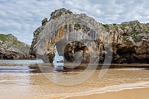 Natural arch of Cuevas del Mar beach, Asturias, Spain photo