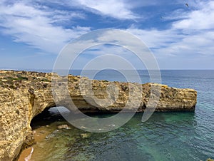 Natural arch and huge cliffs near Olhos de Agua photo
