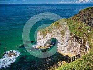 The natural arch known as The Wishing Arch on the Antrim Coast, near Giant`s Causeway, in Northern Ireland, UK.