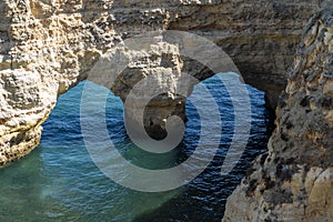 Natural Arch of Marinha Beach during low tide. Landmark in Lagoa, Algarve