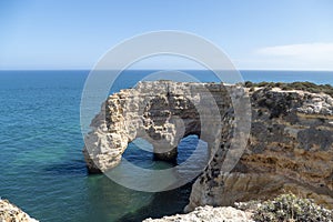 Natural Arch of Marinha Beach during low tide. Landmark in Lagoa, Algarve