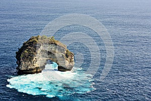 Natural arch surrounded by blue ocean on Nusa Penida Island, Bali, Indonesia