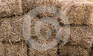 Natural background dry hay stacked in a block livestock feed wall