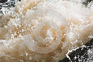 Natural background of rough water foam splashing in a river