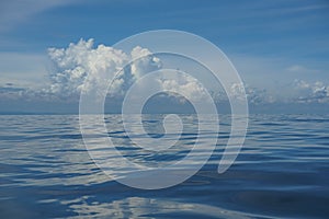 Natural background scene of gradient blue sky horizon and fluffy white cloud above deep blue sea abstract water ripple