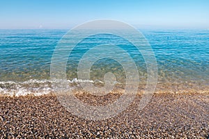 natural background shot of a pebbly beach with no people, no one. Scenic view of empty pebble sea coast on a sunny day