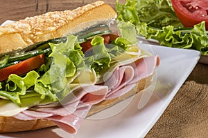Natural baguette sandwich. With cheese, ham and salad